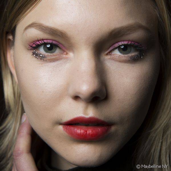 As mais moderninhas podem combinar o vermelho claro nos lábios com sombra colorida rosa e glitter metalizado nos olhos